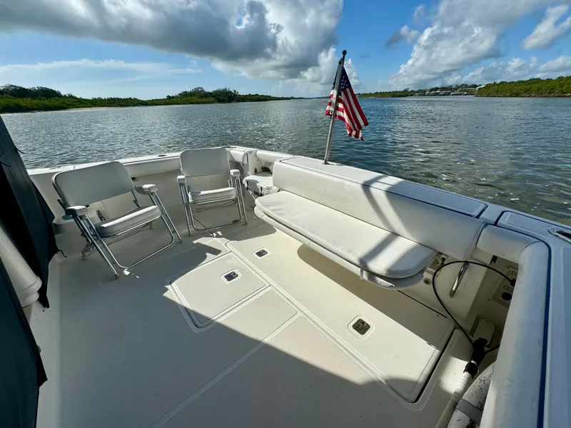 Slide: The Image of 2006 Tiara Yachts 3200 Open boat deck with seating and American flag on calm water. - 15