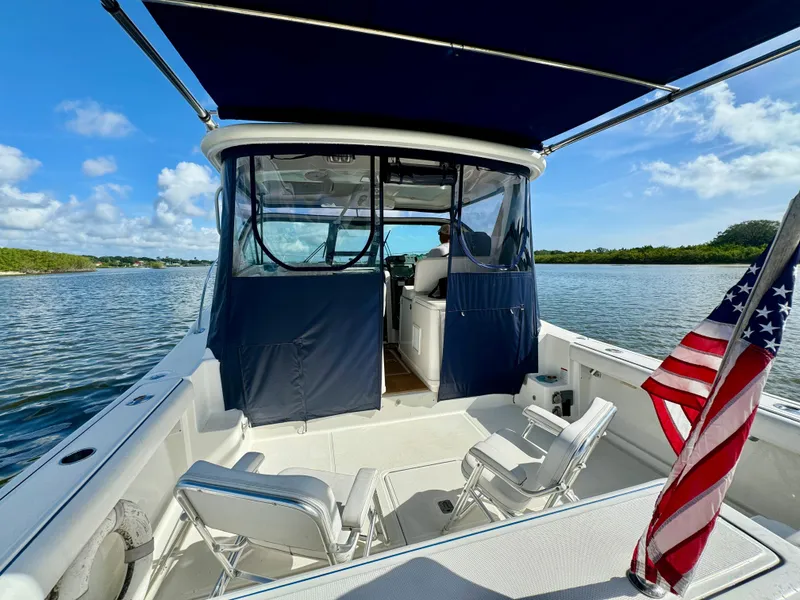 Slide: The Image of 2006 Tiara Yachts 3200 Open on water, featuring seating and American flag. - 16