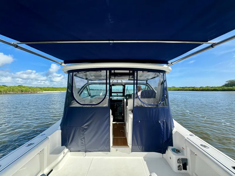 Slide: The Image of 2006 Tiara Yachts 3200 Open on calm water with blue canopy and clear skies. - 17