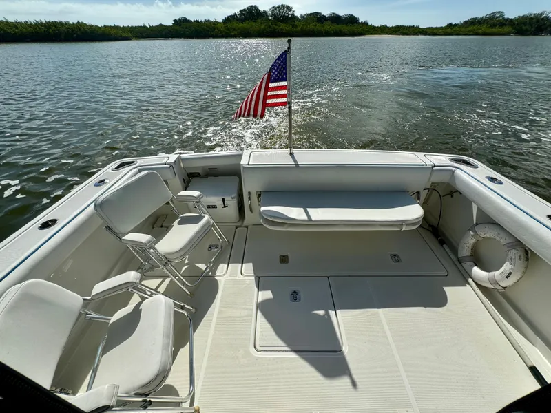Slide: The Image of 2006 Tiara Yachts 3200 Open boat deck with chairs and American flag on water. - 18