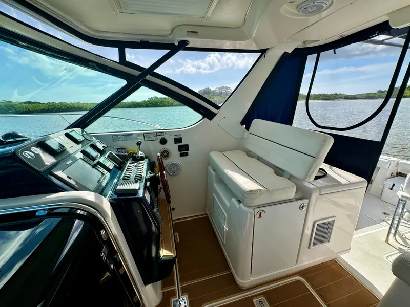 Slide: The Image of 2006 Tiara Yachts 3200 Open cockpit with helm, seating, and scenic water view. - 24