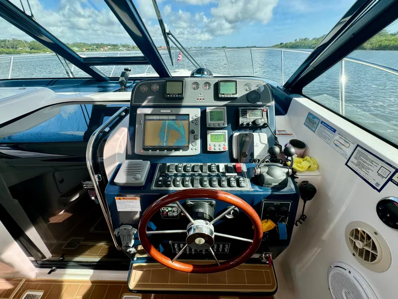 Slide: The Image of Helm of 2006 Tiara Yachts 3200 Open with navigation equipment and wooden steering wheel. - 26