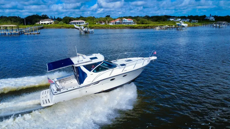 Slide: The Image of 2006 Tiara Yachts 3200 Open cruising on a scenic waterway under a blue sky. - 3