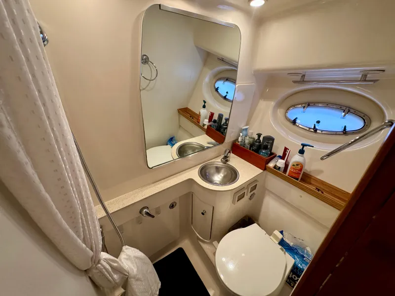 Slide: The Image of Bathroom interior of 2006 Tiara Yachts 3200 Open, featuring sink, mirror, and porthole window. - 37