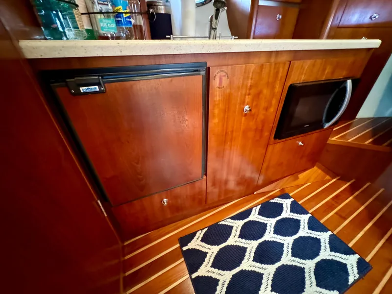 Slide: The Image of 2006 Tiara Yachts 3200 Open galley with wood cabinetry, fridge, and microwave. - 39