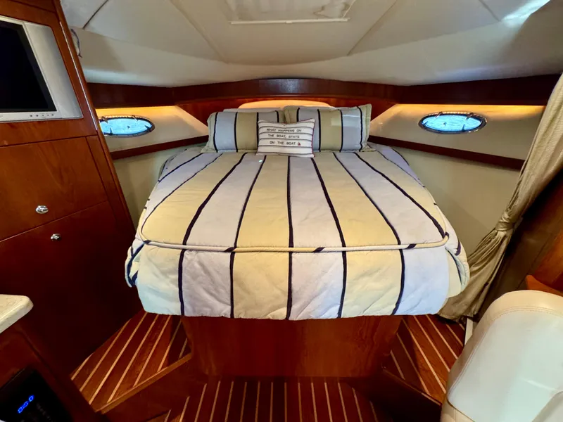 Slide: The Image of Luxurious cabin interior of 2006 Tiara Yachts 3200 Open with striped bedding. - 40