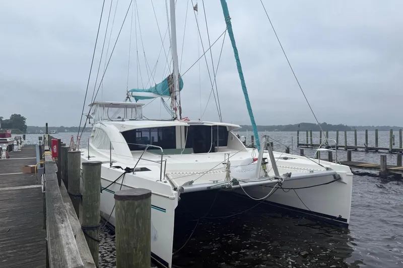 The Image of 2013 Leopard 48 catamaran anchored in calm waters under a clear blue sky. - 0