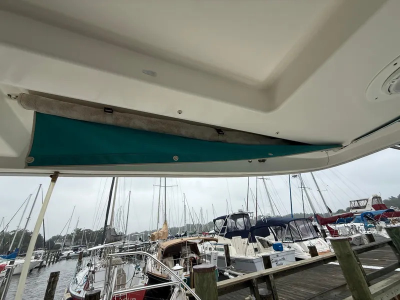 Slide: The Image of Leopard 48 yacht with dinghy on davits, docked at marina, overcast sky. - 10