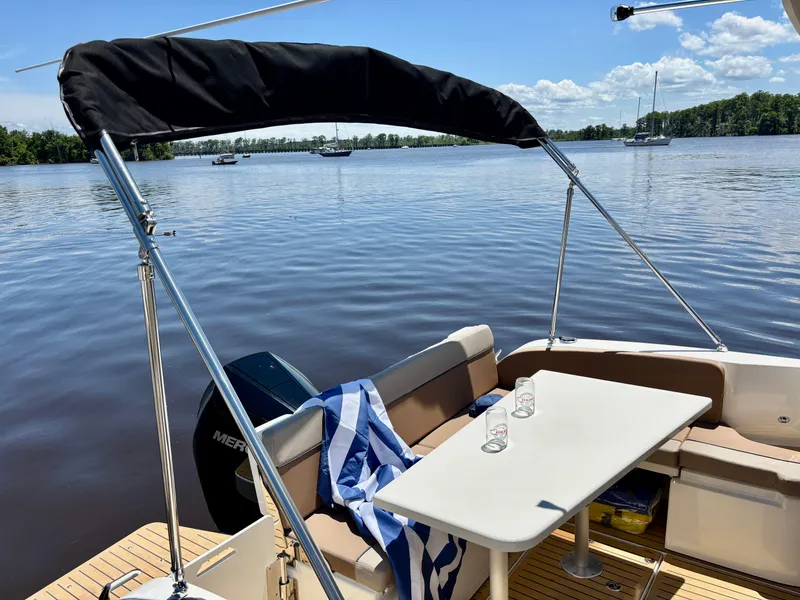 Slide: The Image of 2025 Bayliner TROPHY 25 EXPLORER boat interior with table, seating, and scenic water view. - 2