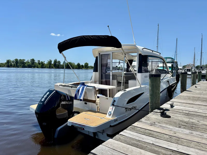 Slide: The Image of 2025 Bayliner TROPHY 25 EXPLORER docked, featuring Mercury outboard motor, under clear blue sky. - 7