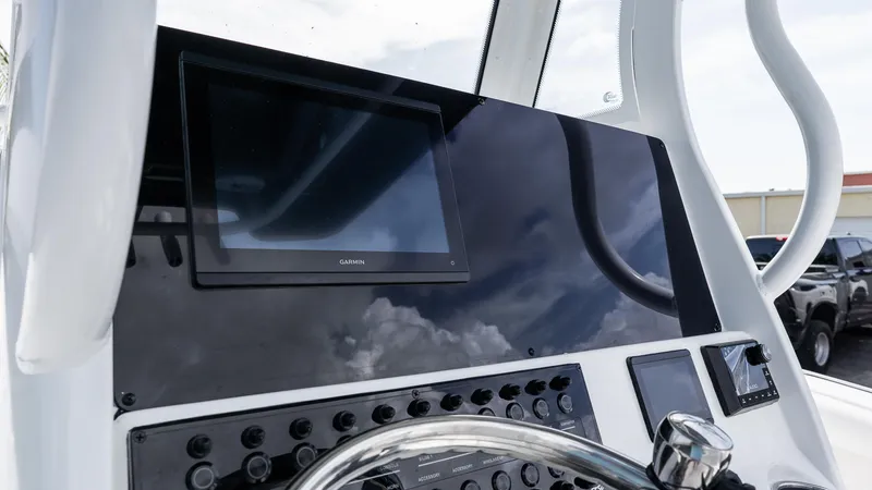 Slide: The Image of 2026 Tidewater 256 CC Adventure boat dashboard with Garmin display and control panel. - 18
