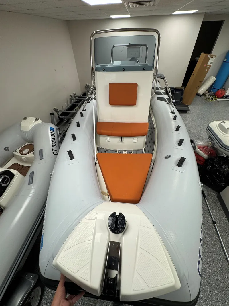 Slide: The Image of 2022 Brig Navigator 570 inflatable boat with orange seating, displayed indoors. - 15