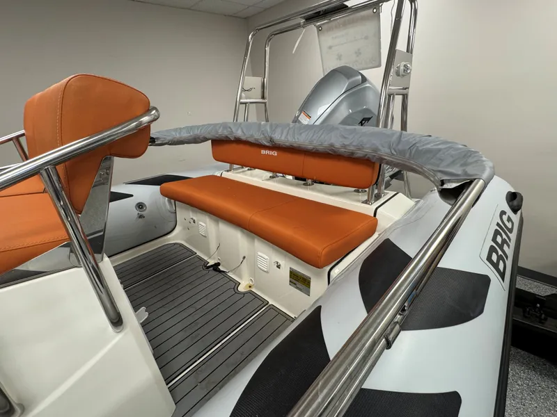 Slide: The Image of 2022 Brig Navigator 570 boat interior with orange seating and stainless steel railings. - 16