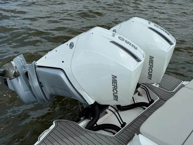 Slide: The Image of 2023 Sea Ray SDX 290 Outboard boat docked by a lake under a cloudy sky. - 3