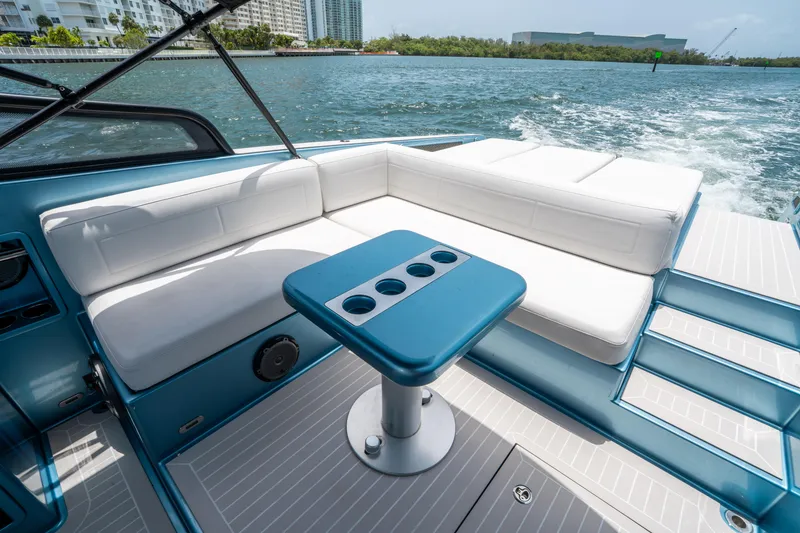 Slide: The Image of Luxurious 2018 VanDutch 30 yacht interior with white seating and blue table on open water. - 16