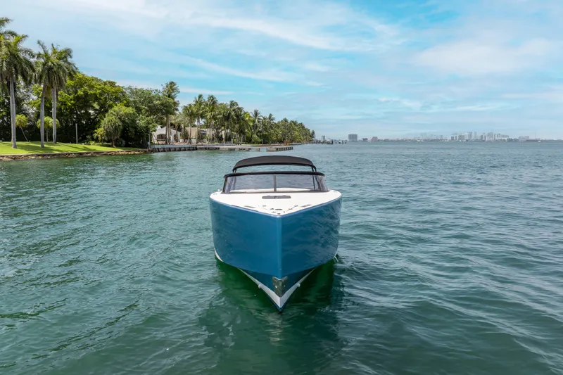 Slide: The Image of 2018 VanDutch 30 yacht on serene water with palm trees and city skyline. - 2