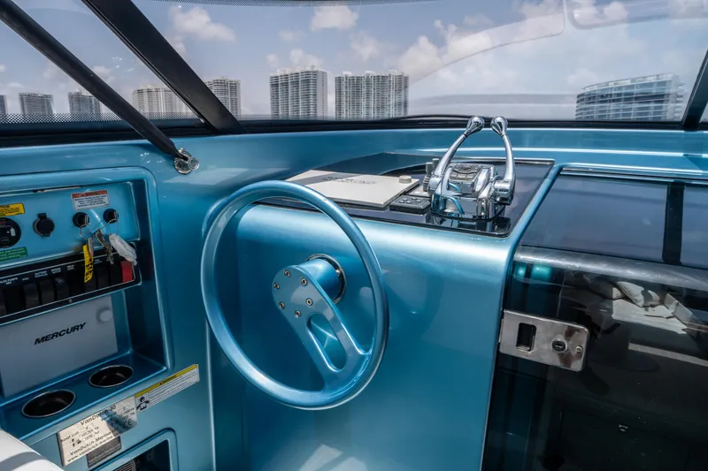 Slide: The Image of 2018 VanDutch 30 yacht cockpit with blue steering wheel and city skyline view. - 20
