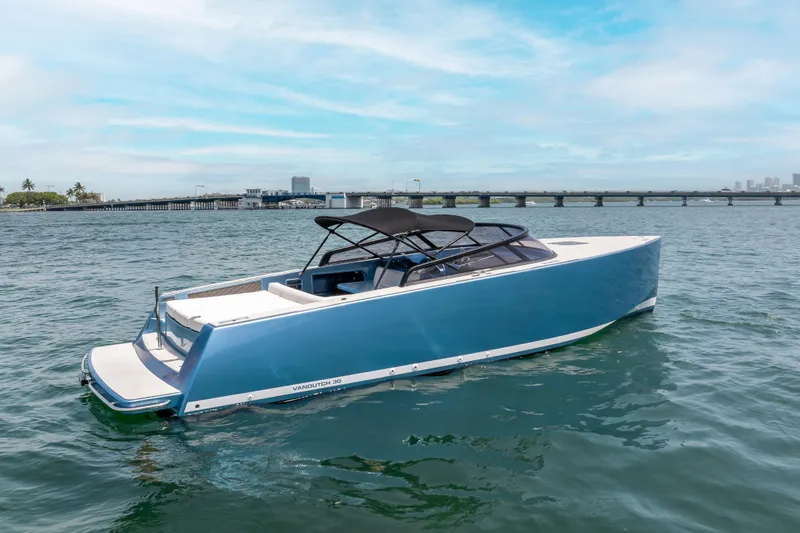 Slide: The Image of 2018 VanDutch 30 yacht on water, sleek design, blue hull, sunny day, bridge in background. - 5