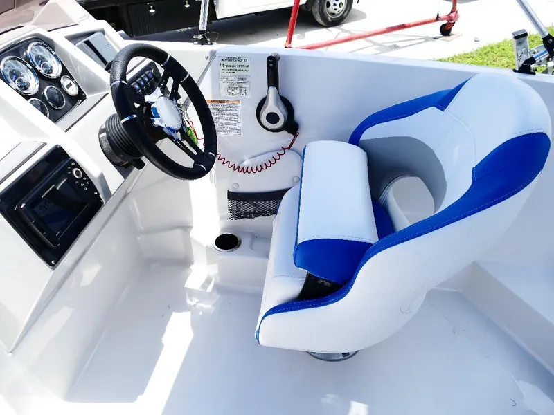 Slide: The Image of 2021 Starcraft SVX 211 OB boat cockpit with steering wheel and blue-white seat. - 16