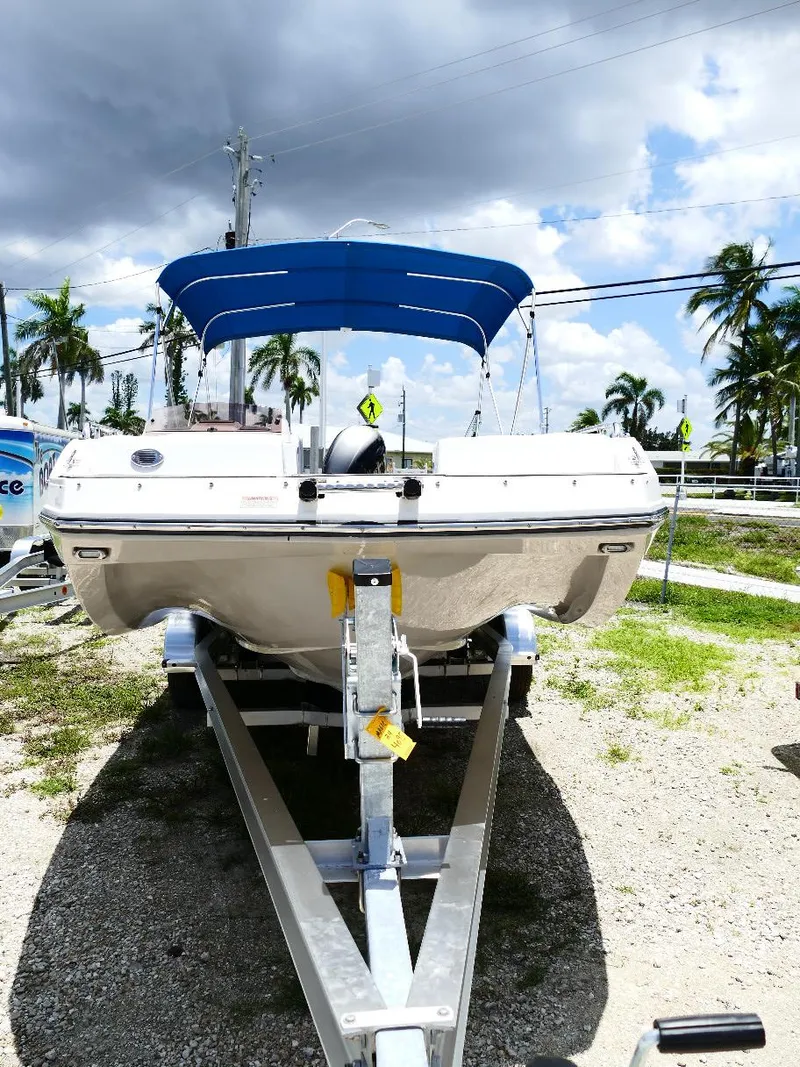 Slide: The Image of 2021 Starcraft SVX 211 OB boat on trailer with blue canopy, parked outdoors. - 3
