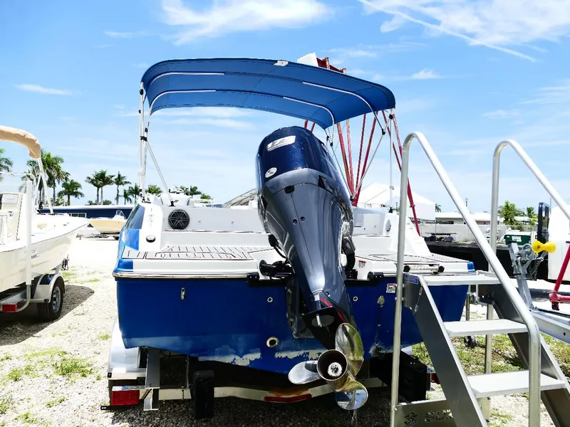 Slide: The Image of 2021 Starcraft SVX 211 OB boat with outboard motor and blue canopy, parked outdoors. - 5