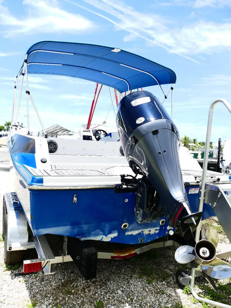 Slide: The Image of 2021 Starcraft SVX 211 OB boat with blue canopy and outboard motor on trailer. - 6