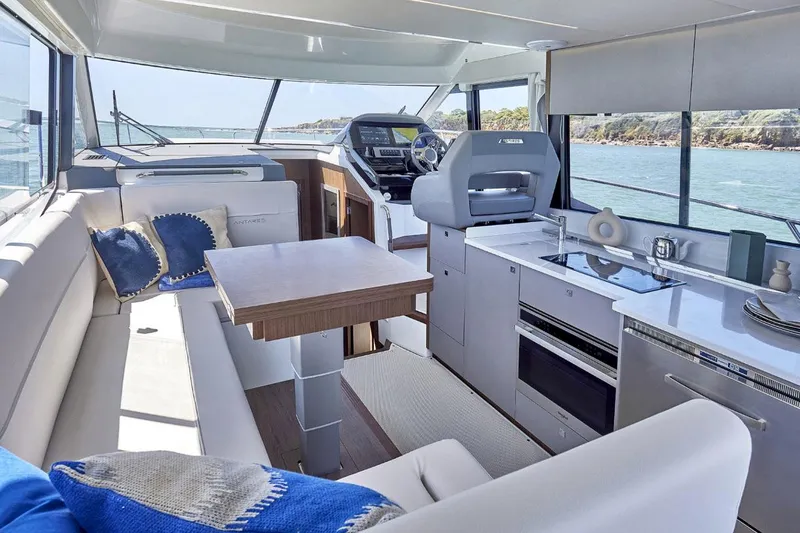Slide: The Image of Luxurious interior of 2025 Beneteau Antares 12 yacht with modern kitchen and seating area. - 4