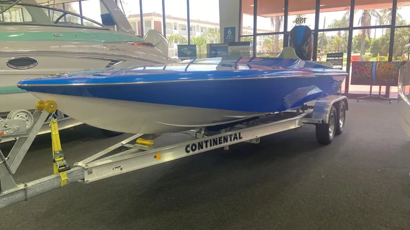 Slide: The Image of 2023 Active Thunder 22 Banshee boat in showroom, blue hull on Continental trailer. - 10