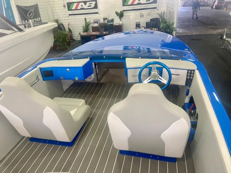 Slide: The Image of 2023 Active Thunder 22 Banshee boat interior with blue dashboard and gray seats. - 6