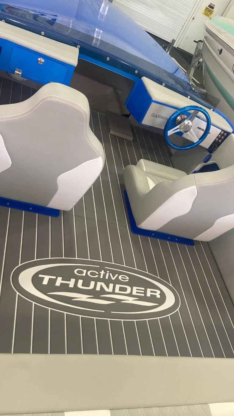 Slide: The Image of 2023 Active Thunder 22 Banshee boat interior with logo, blue accents, and seating. - 9