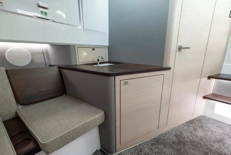 Slide: The Image of Interior of 2025 Axopar 45 Cross Top, featuring modern kitchenette and seating area. - 11