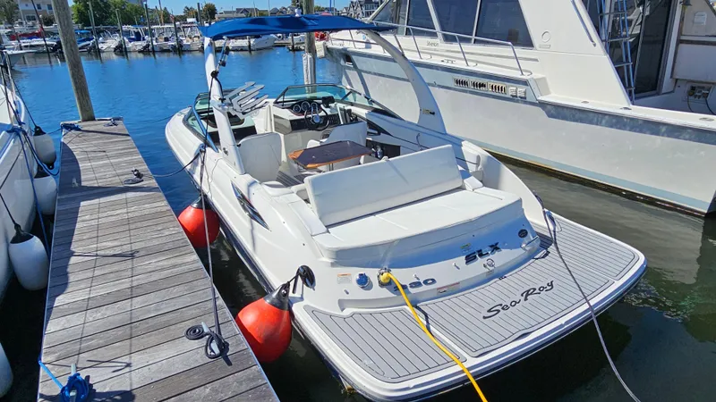 Slide: The Image of 2016 Sea Ray 230 SLX boat docked at marina, featuring sleek design and spacious seating. - 11