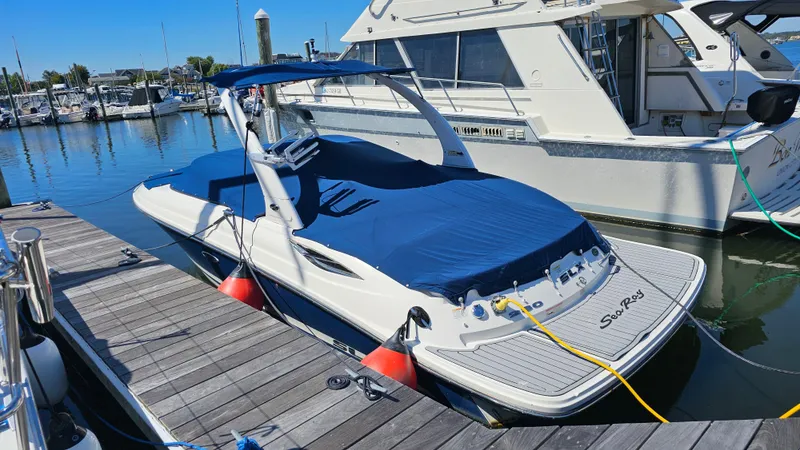 Slide: The Image of 2016 Sea Ray 230 SLX boat docked at marina with blue cover. - 12