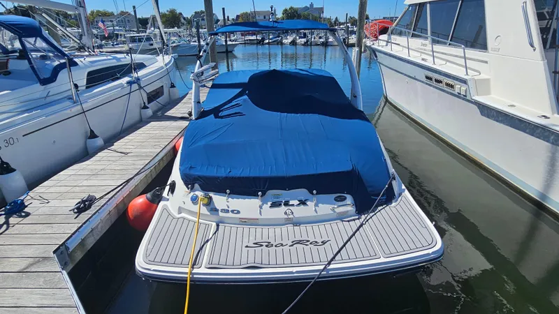 Slide: The Image of 2016 Sea Ray 230 SLX boat docked with blue cover in marina. - 13