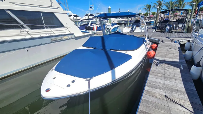 Slide: The Image of 2016 Sea Ray 230 SLX boat docked at marina with blue covers. - 15