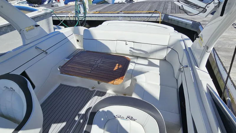 Slide: The Image of 2016 Sea Ray 230 SLX boat interior with white seating and wooden table. - 16