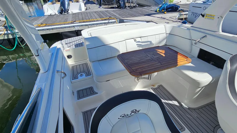 Slide: The Image of 2016 Sea Ray 230 SLX boat interior with white seating and wooden table. - 17