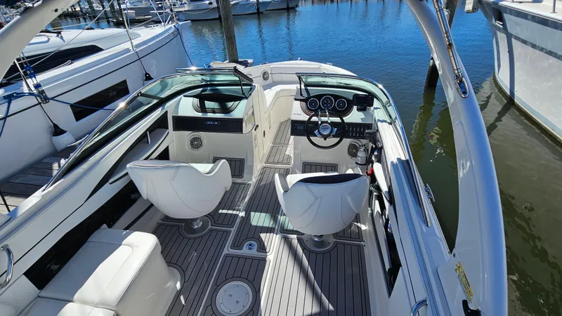 Slide: The Image of 2016 Sea Ray 230 SLX boat interior with white seating and sleek dashboard. - 19