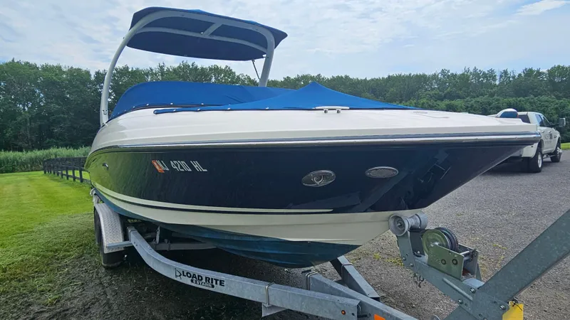 Slide: The Image of 2016 Sea Ray 230 SLX boat on trailer, parked outdoors with blue cover. - 2