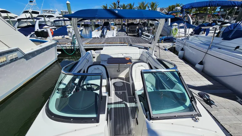 Slide: The Image of 2016 Sea Ray 230 SLX boat docked at marina with blue canopy. - 22