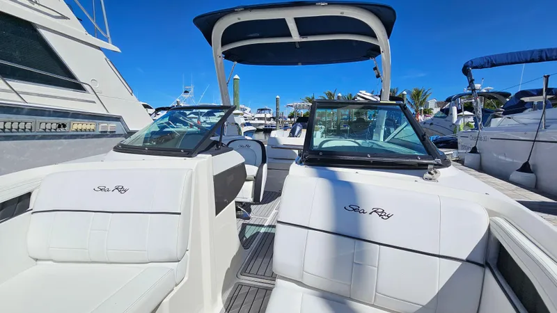 Slide: The Image of 2016 Sea Ray 230 SLX boat interior with white seating and dual windshields. - 24