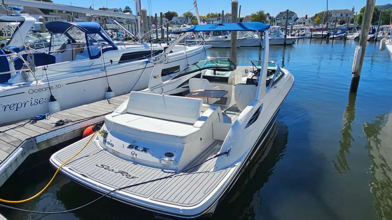 Slide: The Image of 2016 Sea Ray 230 SLX boat docked in a marina, featuring sleek design and spacious seating. - 8