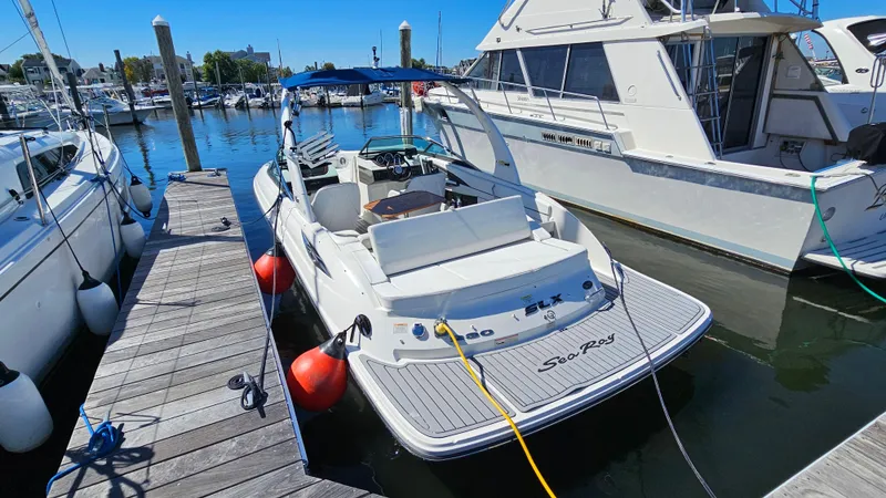 Slide: The Image of 2016 Sea Ray 230 SLX boat docked at marina, sunny day, calm water. - 9