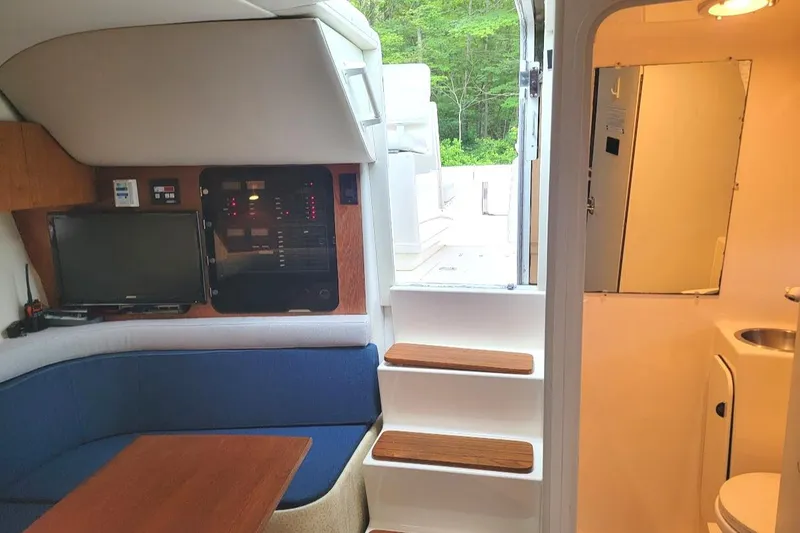 Slide: The Image of Interior of 1995 Tiara Yachts 3100 Open, featuring seating, control panel, and compact bathroom. - 19