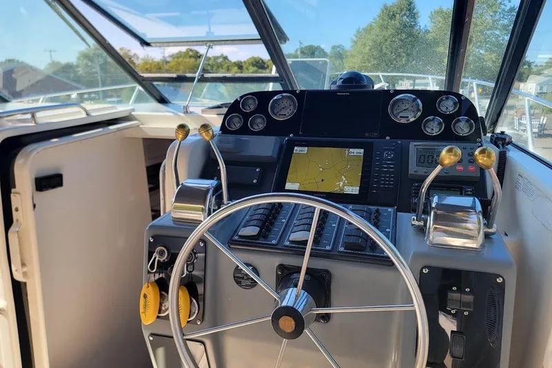 Slide: The Image of Cockpit of 1995 Tiara Yachts 3100 Open, featuring modern navigation controls and steering wheel. - 2