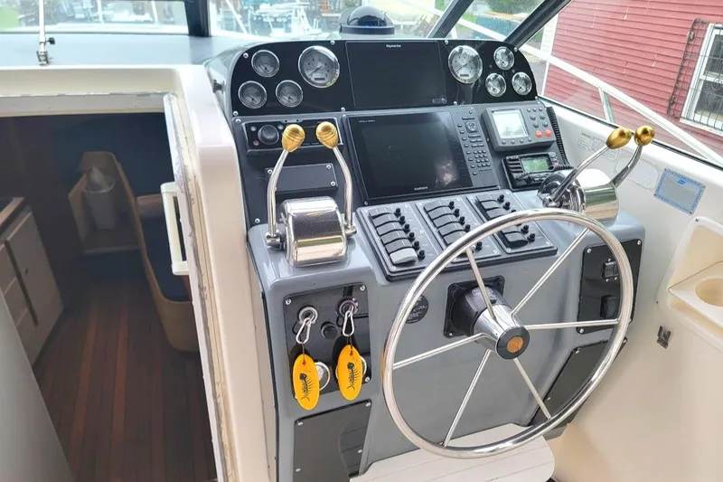 Slide: The Image of 1995 Tiara Yachts 3100 Open helm with modern controls and navigation equipment. - 4