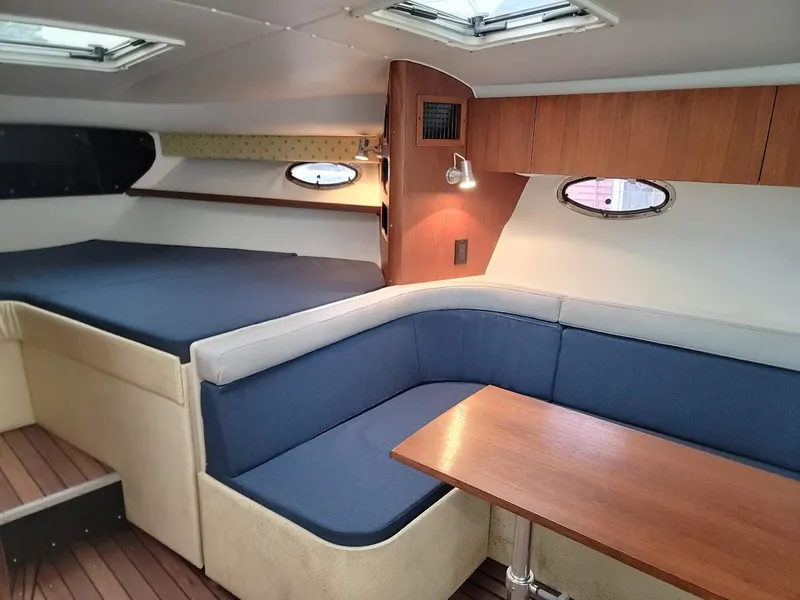 Slide: The Image of Interior of 1995 Tiara Yachts 3100 Open, featuring cozy seating and wooden table. - 5