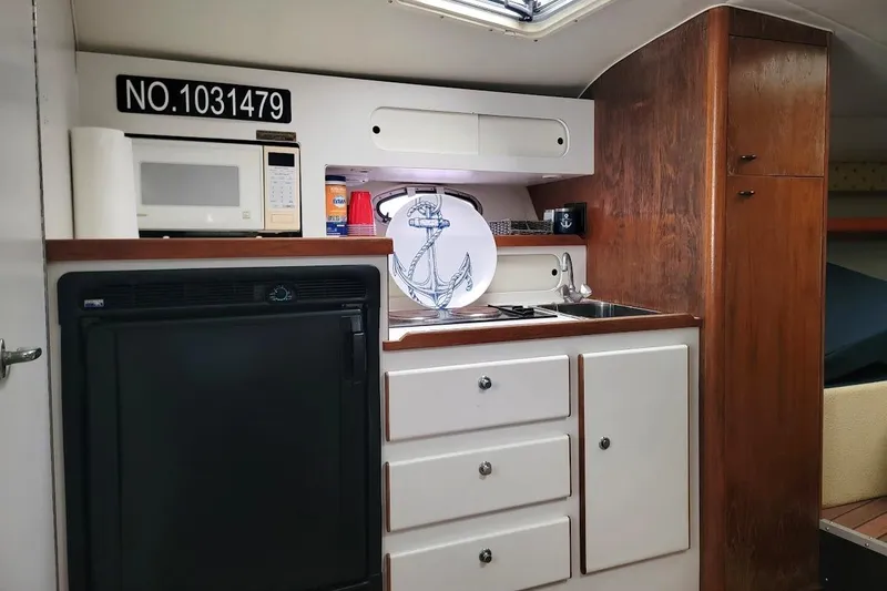 Slide: The Image of 1995 Tiara Yachts 3100 Open interior with kitchenette, featuring microwave and sink. - 9