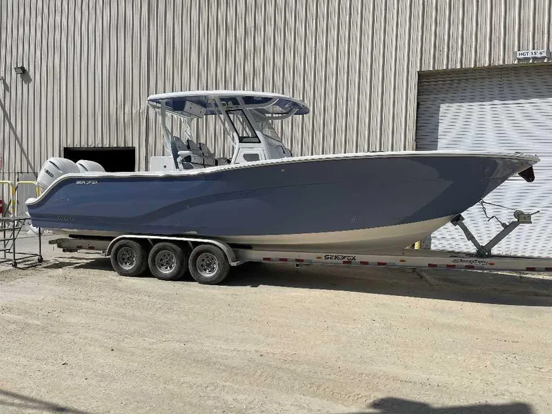 Slide: The Image of 2025 Sea Fox 328 Commander boat on trailer, parked outside industrial building. - 1