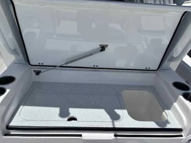 Slide: The Image of 2025 Sea Fox 328 Commander storage compartment with open lid and cup holders. - 17